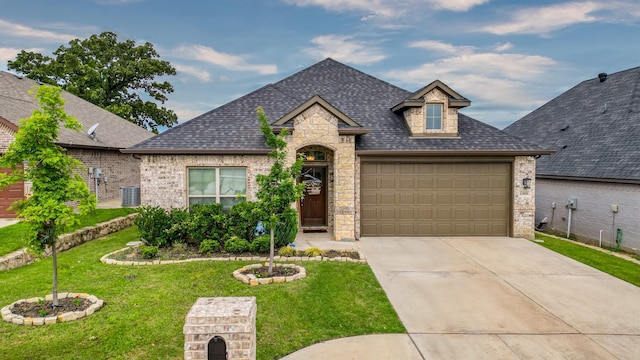 french country style house with a front yard, a garage, and central AC