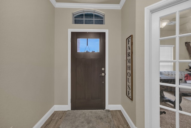 entrance foyer featuring ceiling fan, ornamental molding, and light hardwood / wood-style flooring