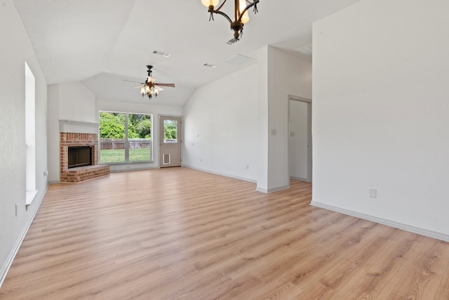 unfurnished living room featuring a fireplace, light hardwood / wood-style flooring, ceiling fan with notable chandelier, and vaulted ceiling