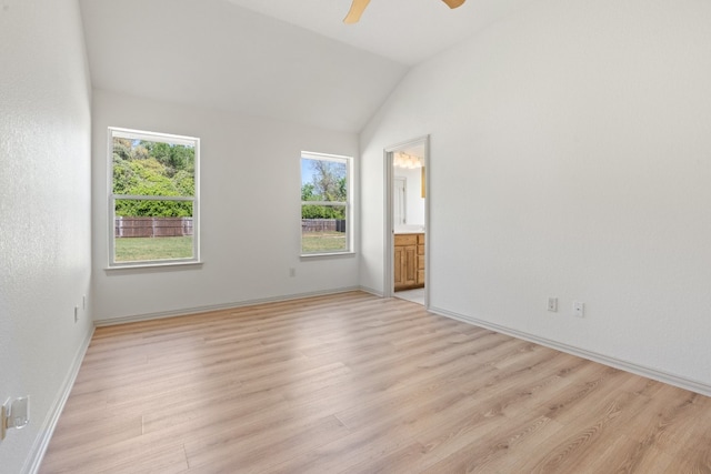 spare room with light hardwood / wood-style flooring, ceiling fan, lofted ceiling, and plenty of natural light