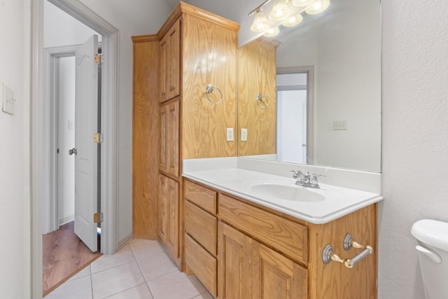 bathroom with toilet, tile floors, and vanity with extensive cabinet space