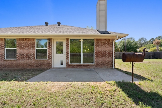 back of property featuring a lawn and a patio area