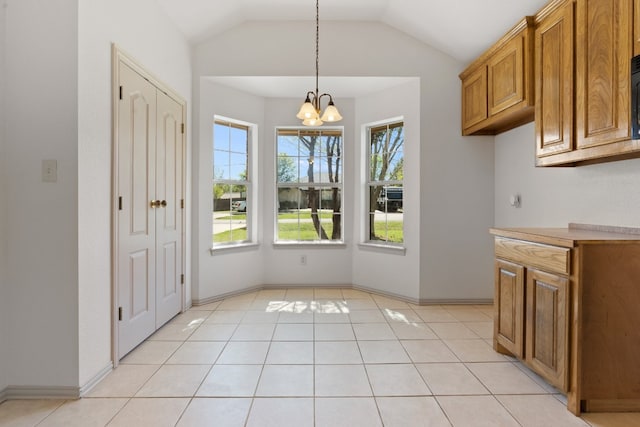 unfurnished dining area featuring light tile floors, vaulted ceiling, and an inviting chandelier