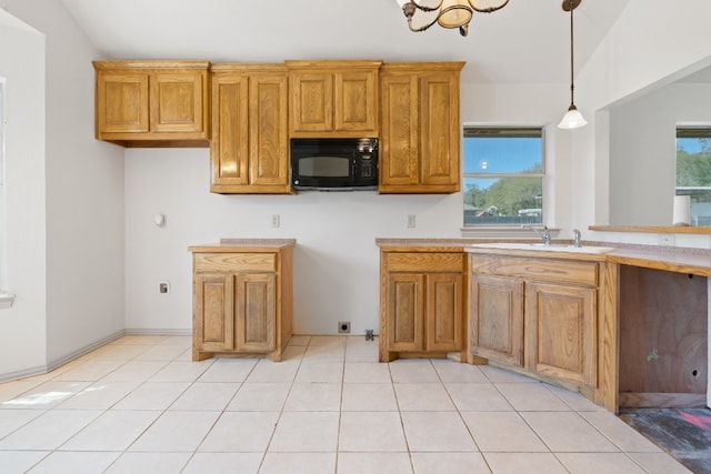 kitchen with lofted ceiling, sink, light tile floors, and plenty of natural light