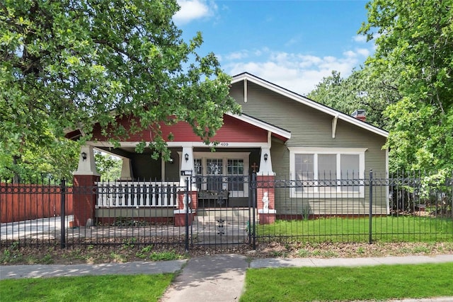 bungalow-style home with a front lawn and covered porch