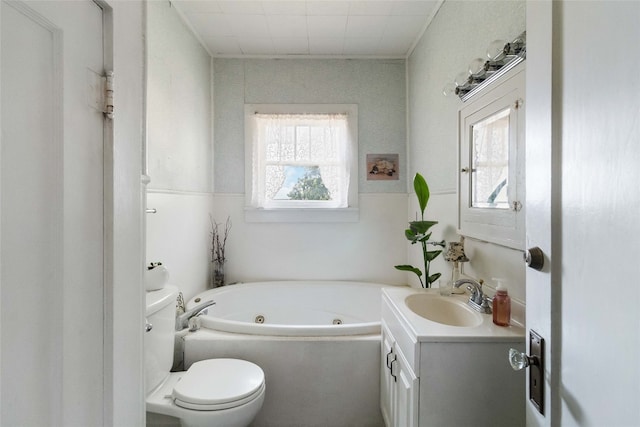 bathroom featuring a healthy amount of sunlight, oversized vanity, toilet, and a bath to relax in