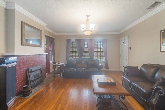 living room with dark hardwood / wood-style flooring, a chandelier, a textured ceiling, and crown molding