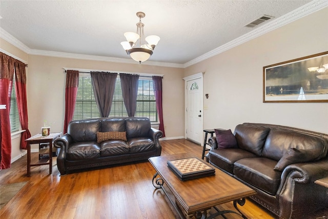 living room with a notable chandelier, wood-type flooring, a textured ceiling, and crown molding