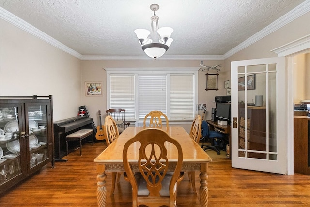 dining space with hardwood / wood-style floors, ornamental molding, and a textured ceiling