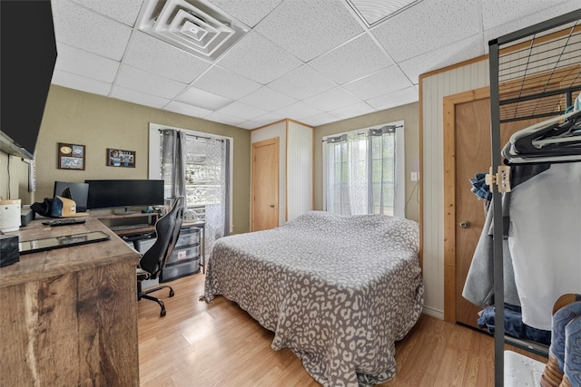 bedroom featuring a paneled ceiling and light wood-type flooring