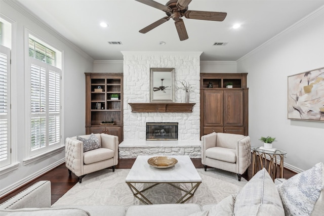 living room featuring a fireplace, light wood-type flooring, ceiling fan, and ornamental molding