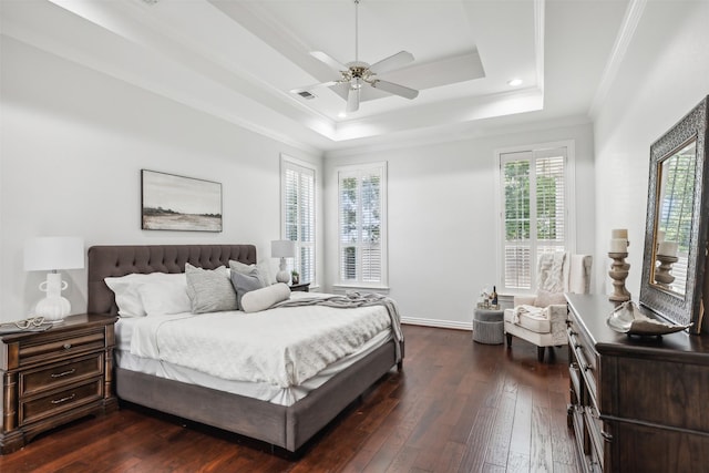 bedroom with a tray ceiling, ceiling fan, dark wood-type flooring, and ornamental molding