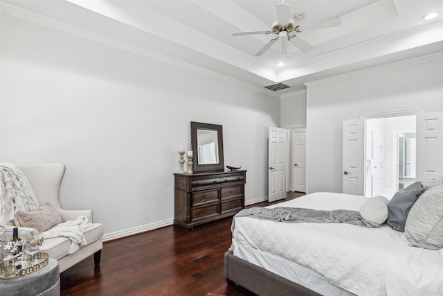 bedroom with ceiling fan, dark hardwood / wood-style flooring, crown molding, and a tray ceiling