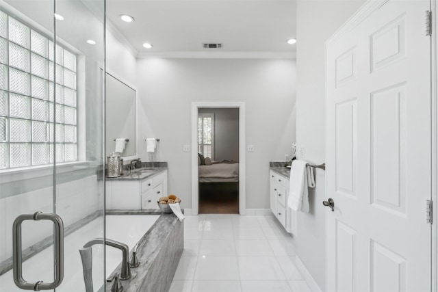 bathroom with tile patterned flooring, plenty of natural light, ornamental molding, and tiled bath