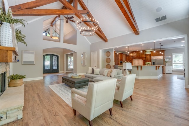 living room with crown molding, french doors, light hardwood / wood-style floors, beam ceiling, and high vaulted ceiling