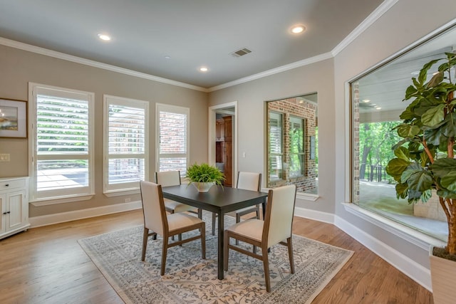 dining space featuring crown molding and light hardwood / wood-style floors