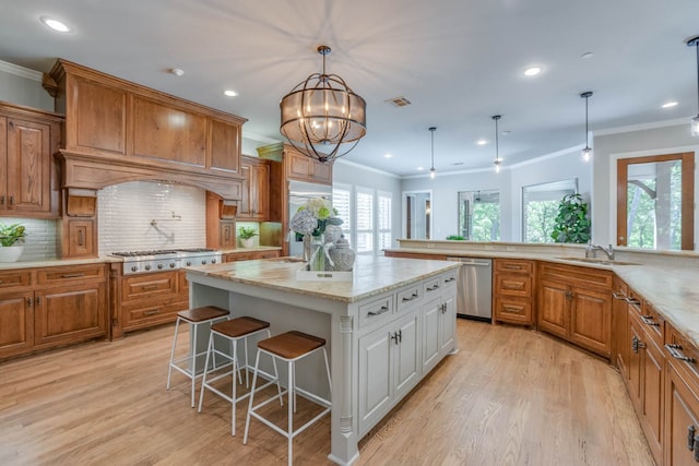 kitchen featuring white cabinetry, appliances with stainless steel finishes, a wealth of natural light, and a kitchen bar