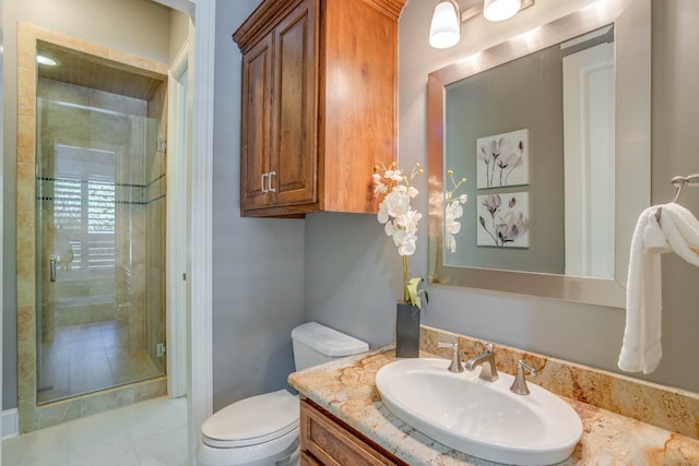 bathroom featuring vanity, tile patterned floors, toilet, and walk in shower