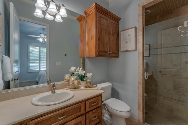 bathroom with vanity, a shower with shower door, toilet, and ceiling fan with notable chandelier