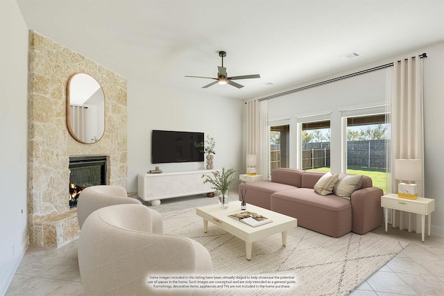 living room featuring a fireplace, light tile patterned floors, and ceiling fan