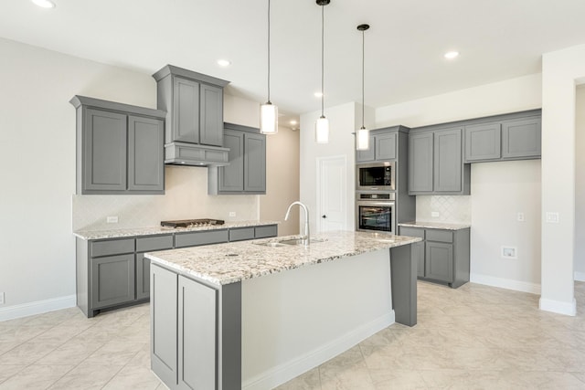 kitchen with stainless steel appliances, light stone counters, gray cabinetry, and sink