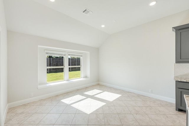 interior space with vaulted ceiling and light tile patterned flooring