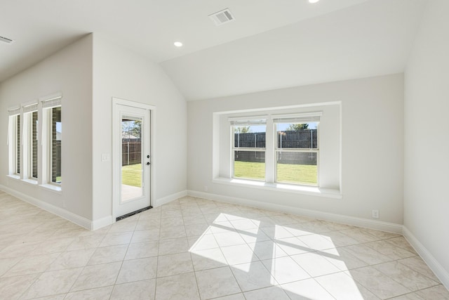 unfurnished room with light tile patterned floors and lofted ceiling