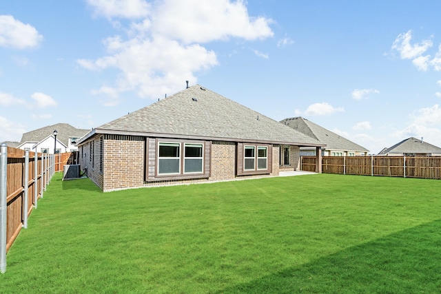 rear view of house featuring a lawn and central air condition unit