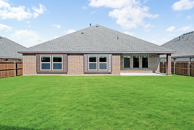 rear view of property featuring a lawn