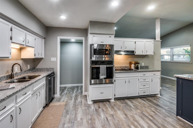 kitchen with white cabinetry, stainless steel appliances, sink, and light stone counters