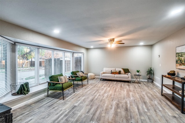 living room featuring ceiling fan and light hardwood / wood-style flooring