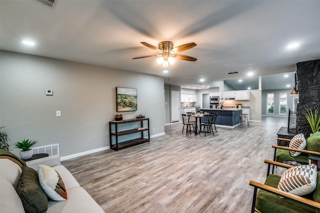 living room featuring ceiling fan and light hardwood / wood-style flooring