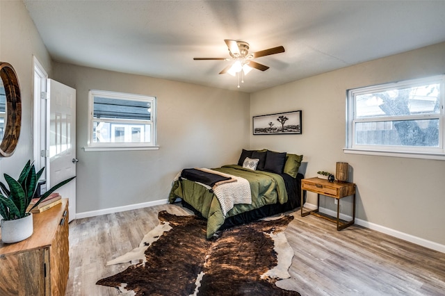 bedroom featuring multiple windows, light hardwood / wood-style flooring, and ceiling fan