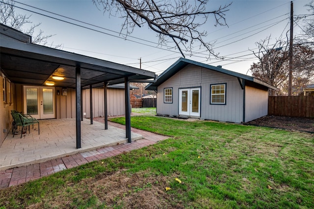 rear view of house with french doors, a patio area, and a lawn