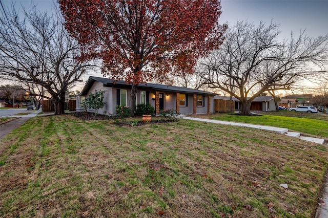 ranch-style home with a yard