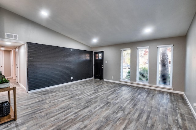 unfurnished living room featuring lofted ceiling and wood-type flooring