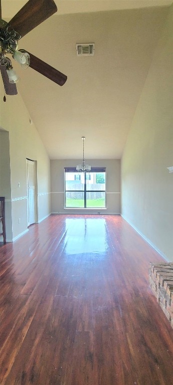 spare room featuring ceiling fan with notable chandelier, wood-type flooring, and high vaulted ceiling