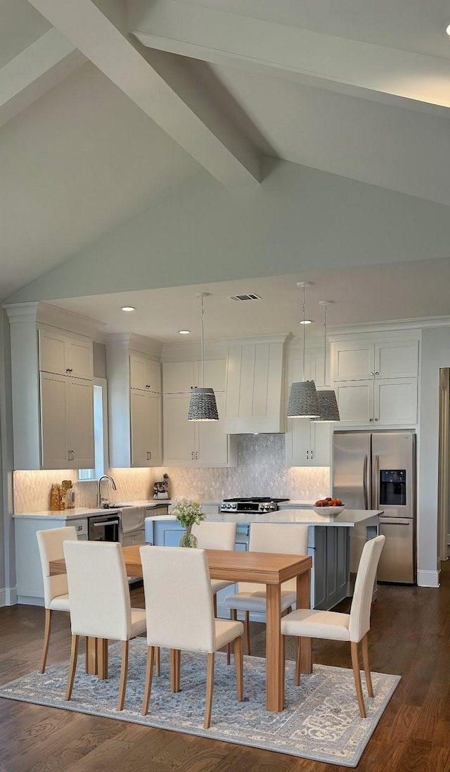 kitchen featuring stainless steel refrigerator with ice dispenser, white cabinetry, a center island, hanging light fixtures, and custom range hood