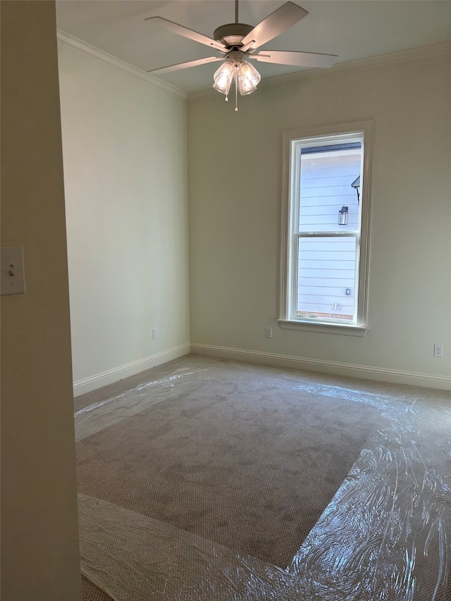 spare room featuring crown molding, a ceiling fan, baseboards, and carpet floors