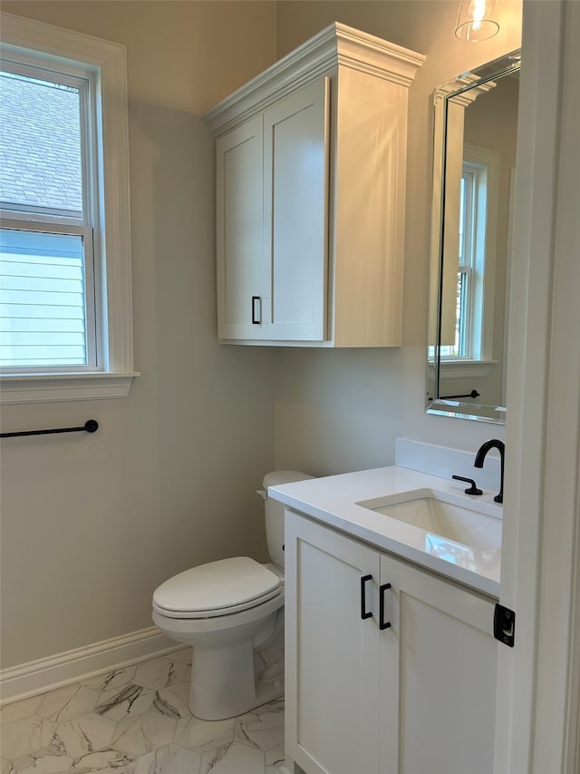 bathroom with baseboards, toilet, marble finish floor, and vanity