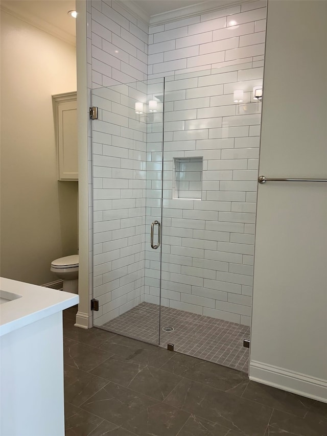 bathroom with a shower stall, toilet, crown molding, and baseboards