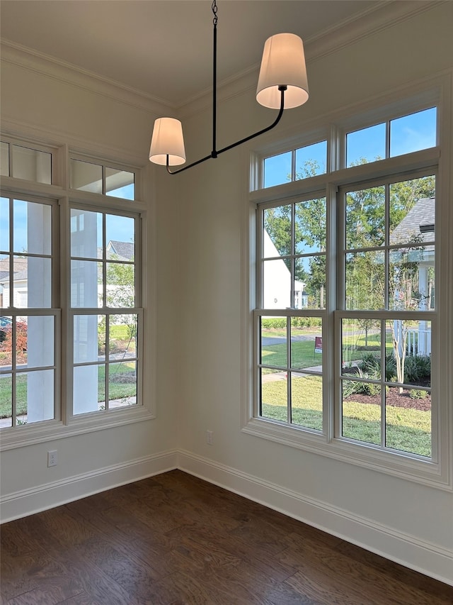 unfurnished dining area featuring baseboards, dark wood-type flooring, and crown molding