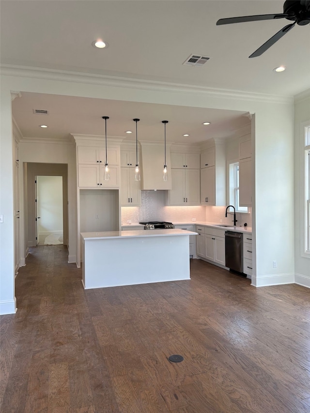 kitchen featuring visible vents, a center island, dishwasher, light countertops, and white cabinets