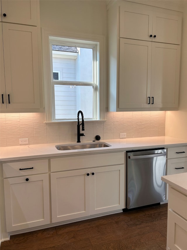 kitchen featuring a sink, tasteful backsplash, stainless steel dishwasher, and white cabinetry