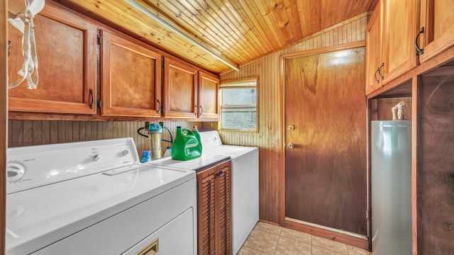 laundry area with wood ceiling, wooden walls, water heater, and washer and dryer