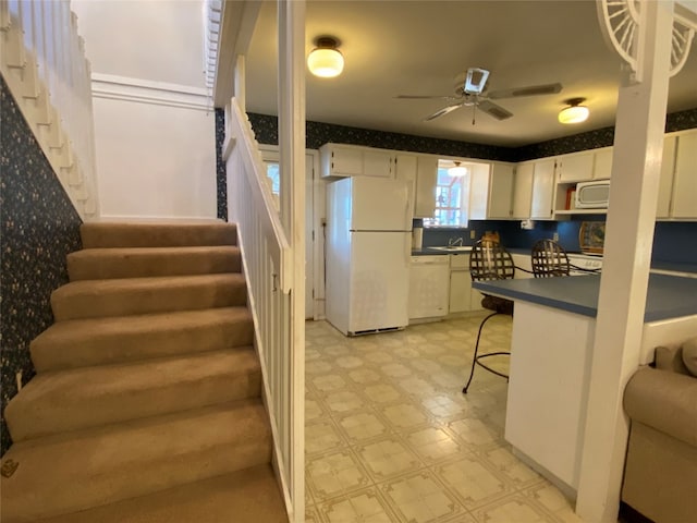 interior space featuring light tile floors, ceiling fan, and sink