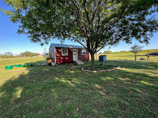 view of yard with a rural view and a storage shed