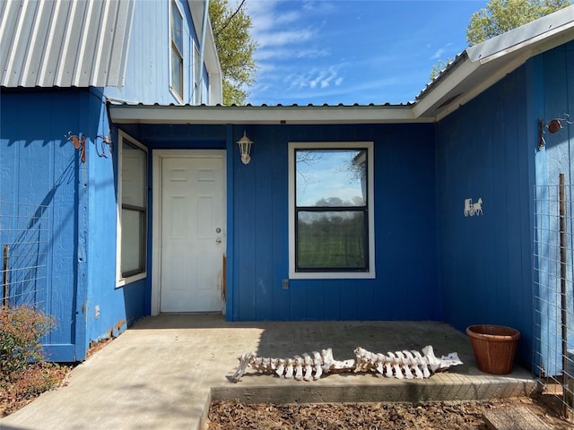 view of exterior entry with a patio