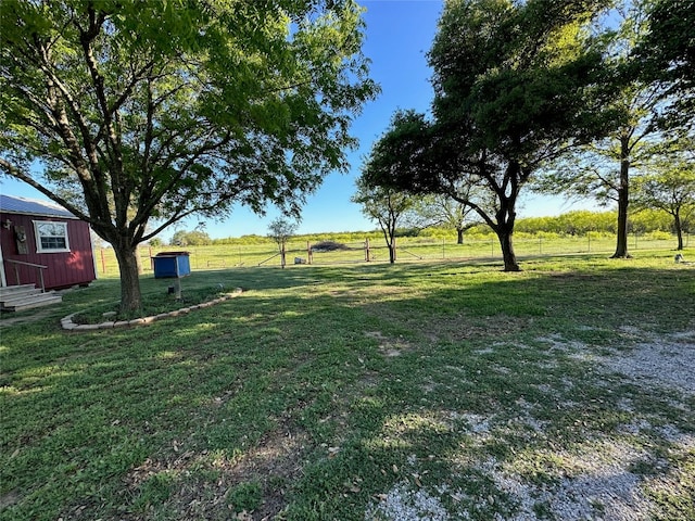 view of yard with a rural view and an outdoor structure