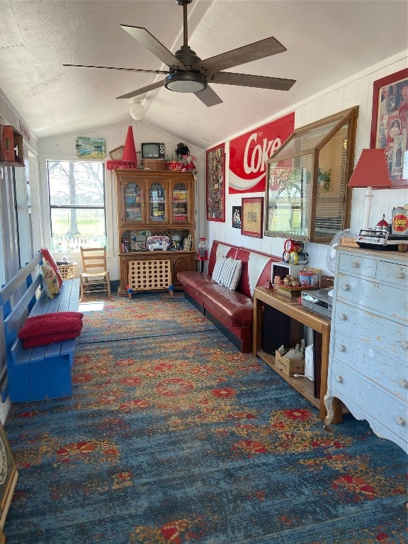 living room featuring vaulted ceiling, ceiling fan, and dark carpet